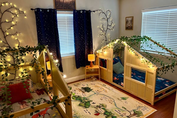 Cabin themed beds with string lights in a themed room for kids
